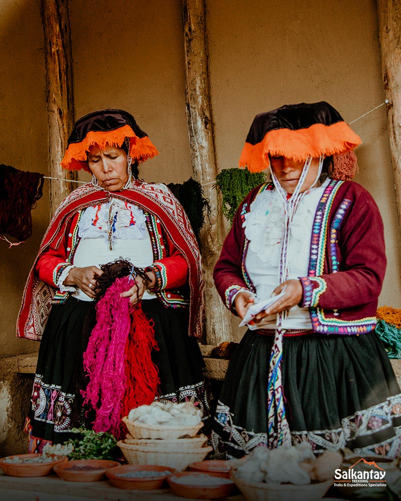 Duas mulheres andinas de Chinchero tecendo e explicando o processo de tecelagem.