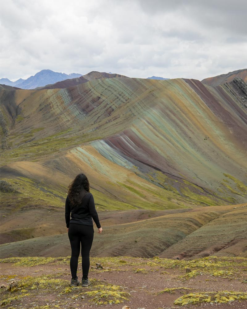 Turista em pé olhando para a Montanha Colorida de Palccoyo