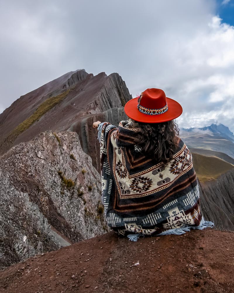 Turista com roupa andina na montanha colorida de Pallay Punchu