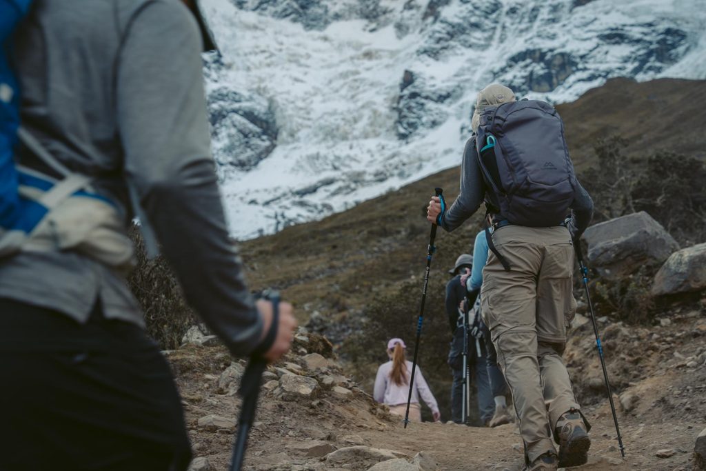 Grupo de turistas que percorrem a trilha de Salkantay com bastões de trekking adequados.