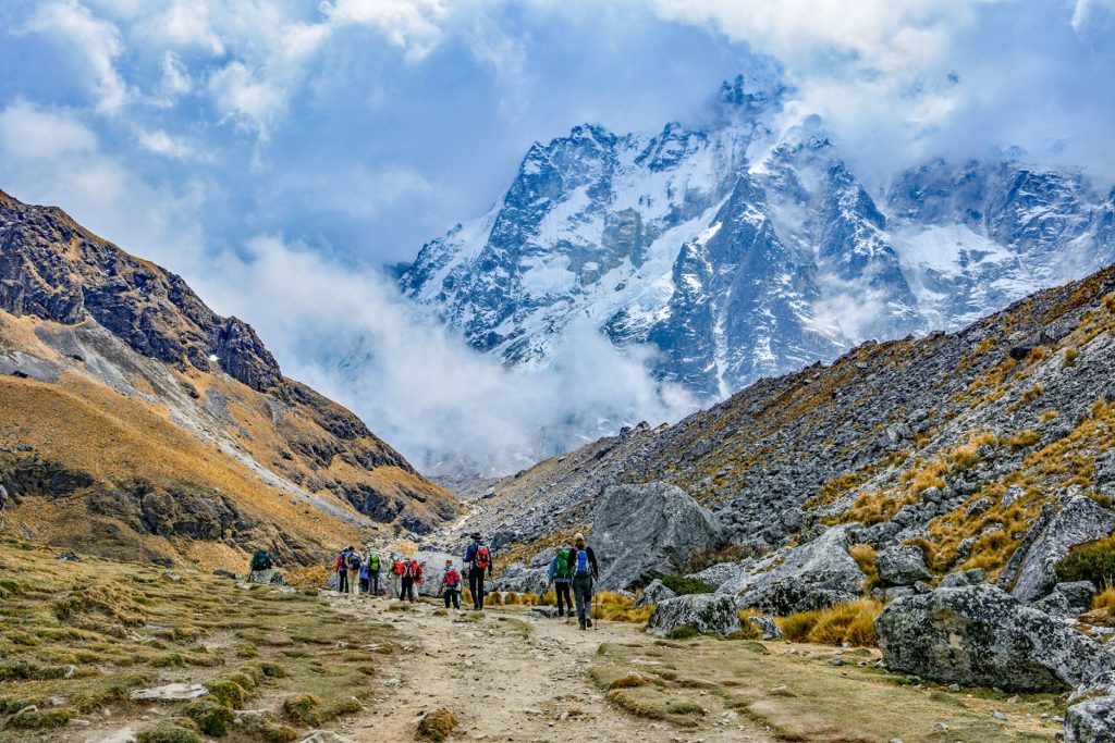 Grupo de turistas caminhando em direção à montanha nevada de Salkantay