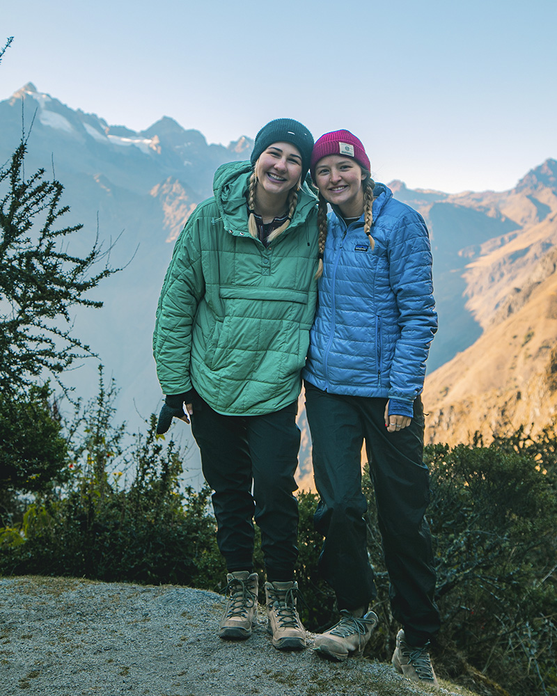 Duas mulheres posando em uma paisagem da Trilha Inca