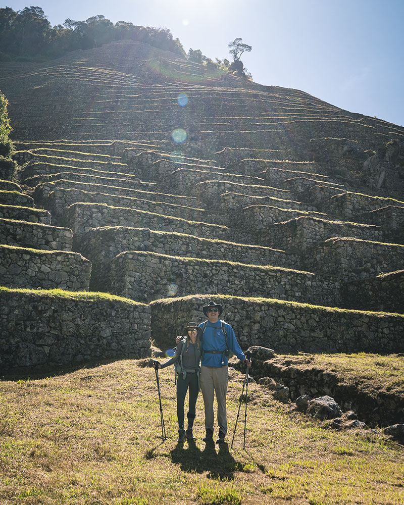 Dois turistas posando no sítio arqueológico de Wiñay Wayna