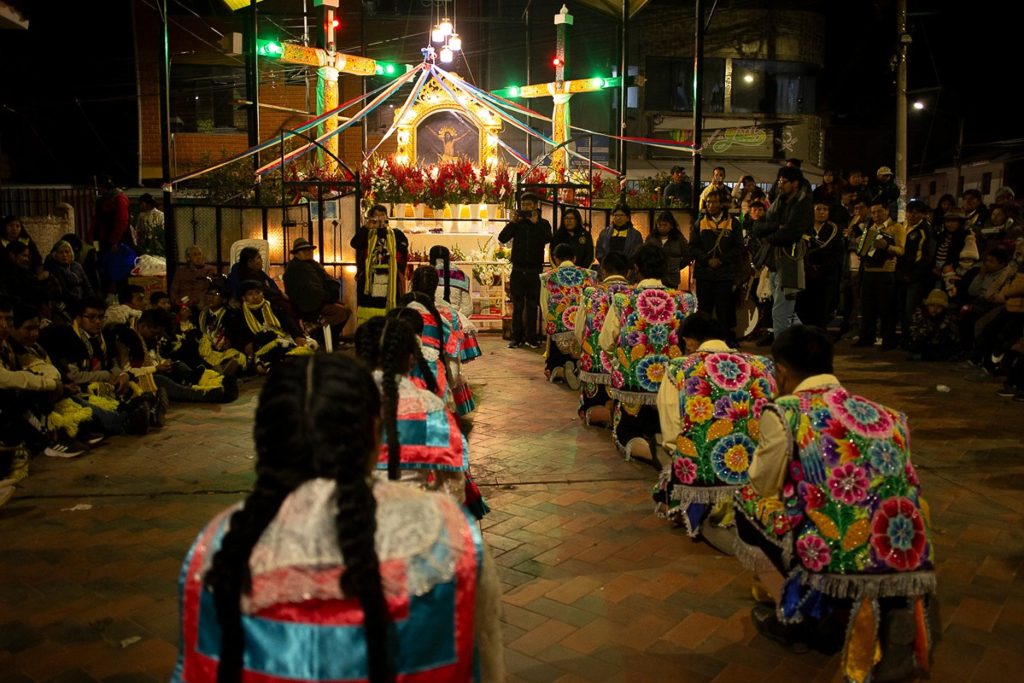 Dançarinos ajoelhados na Cruz Velacuy em Cuzco
