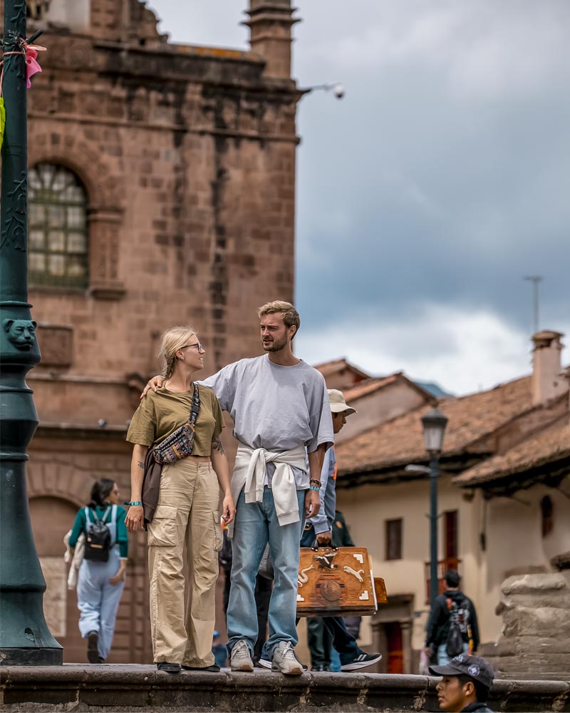Um casal de turistas caminhando na cidade de Cusco.
