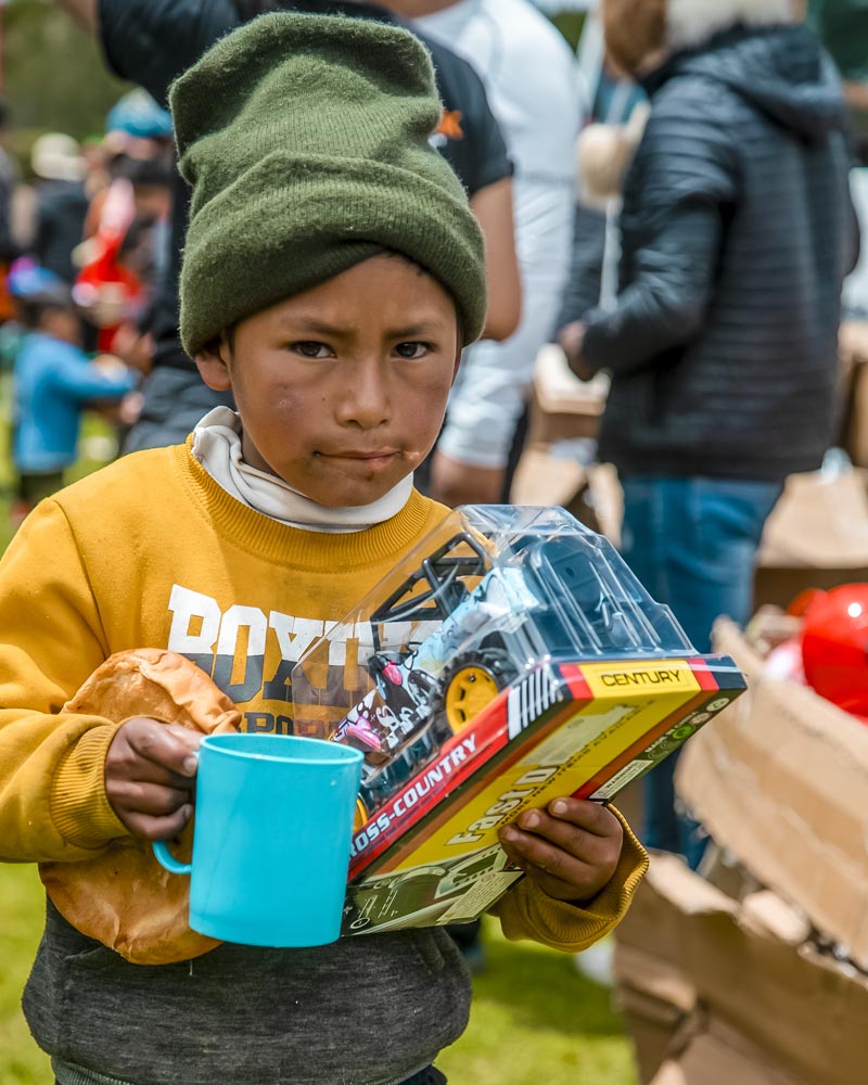 Menino com seu brinquedo e xícara de chocolate da Ausangate na campanha de Natal desenvolvida pela Salkantay Trekking.