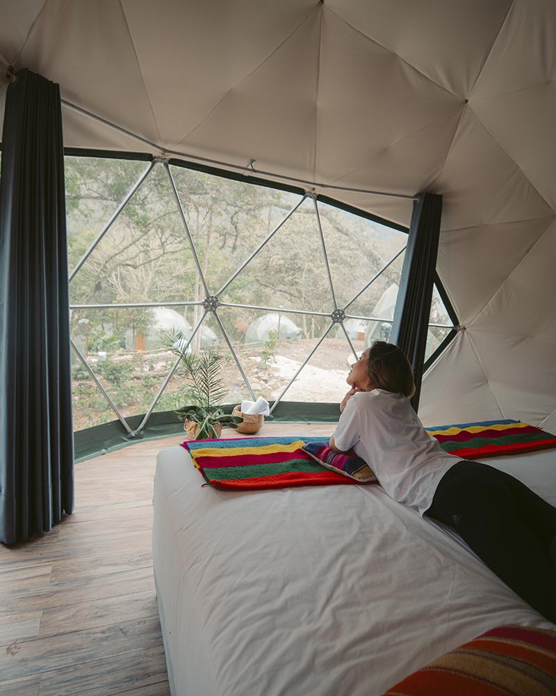 Turista dentro de um domo no acampamento Super Jungle Domes