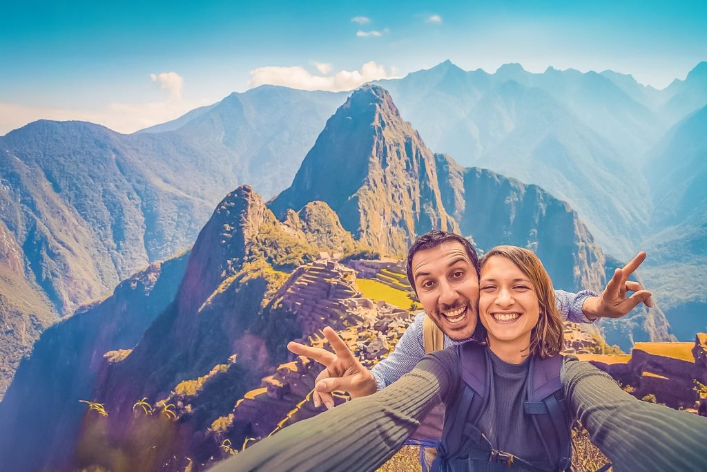 Um casal de turistas felizes na cidadela de Machu Picchu