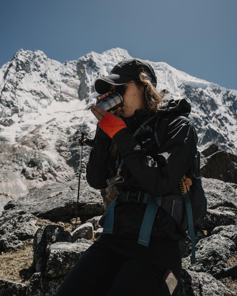 Turista bebendo chá de coca no Passo de Salkantay.