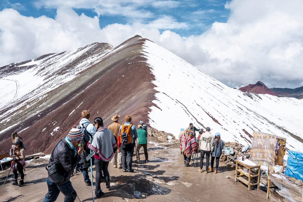 Foto panorâmica de grupos de turistas na Montanha Arco-Íris de Vinicunca.