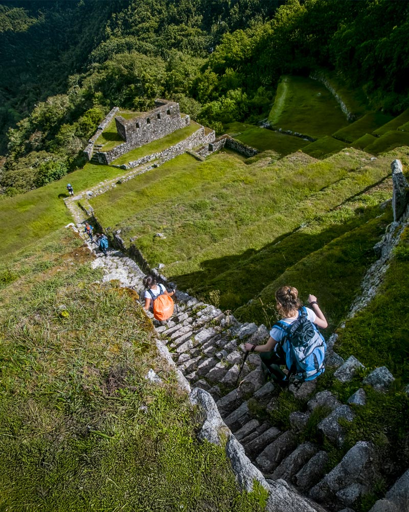 Turistas nas escadas de pedra ao longo do Caminho Inca