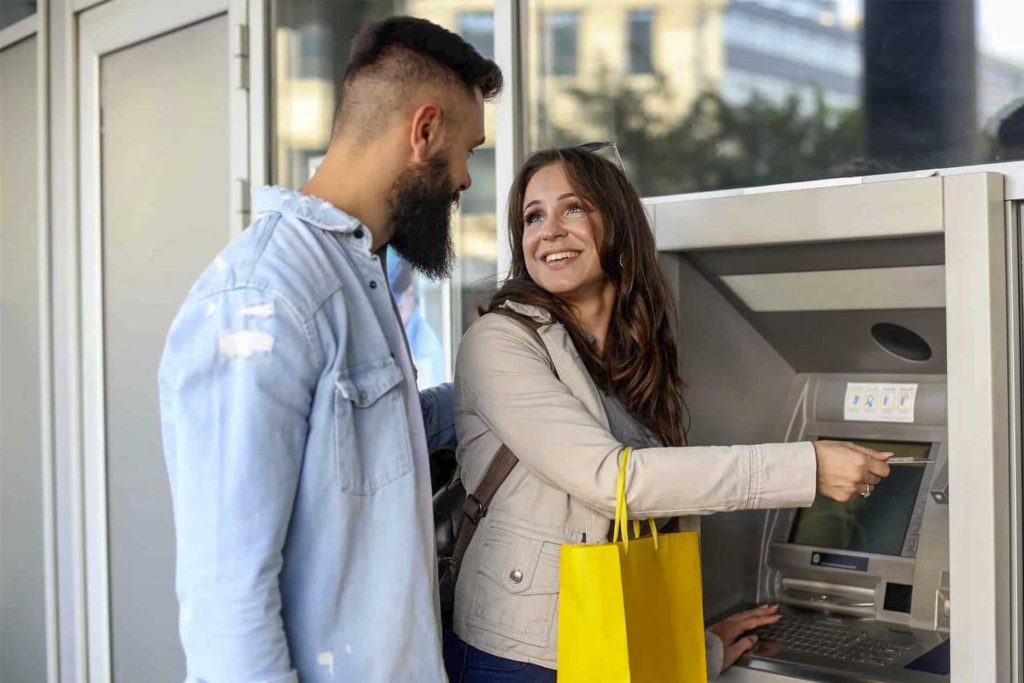 Casal usando caixa eletrônico