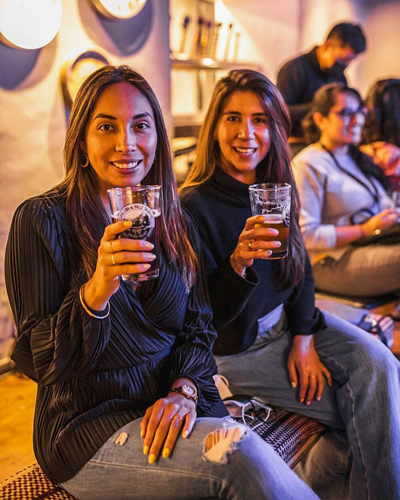 Duas raparigas a beber cerveja artesanal em Cusco