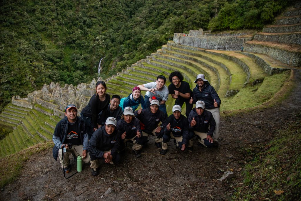 Grupo de turistas e equipe de excursionistas no sítio arqueológico de Wiñay Wayna, na Trilha Inca.