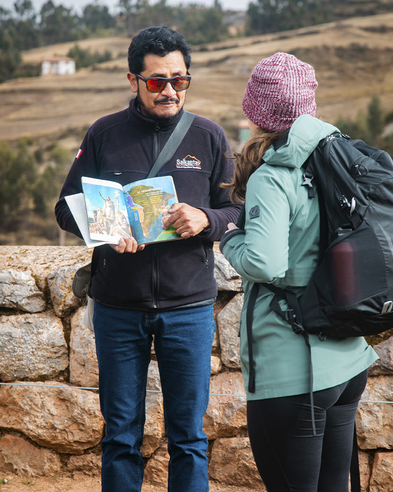 Guia turístico da Salkantay Trekking explicando a uma turista no sítio arqueológico de Chinchero a história e a arquitetura da época
