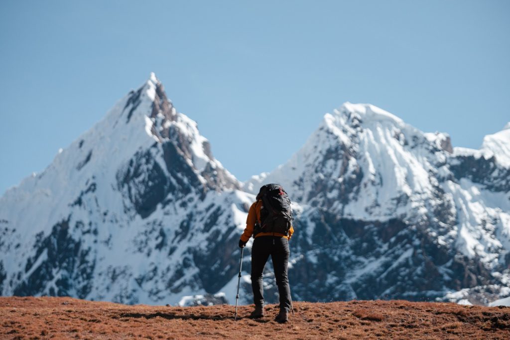 Um caminhante nos Andes peruanos, cercado por montanhas cobertas de neve, passando por uma desintoxicação digital na natureza