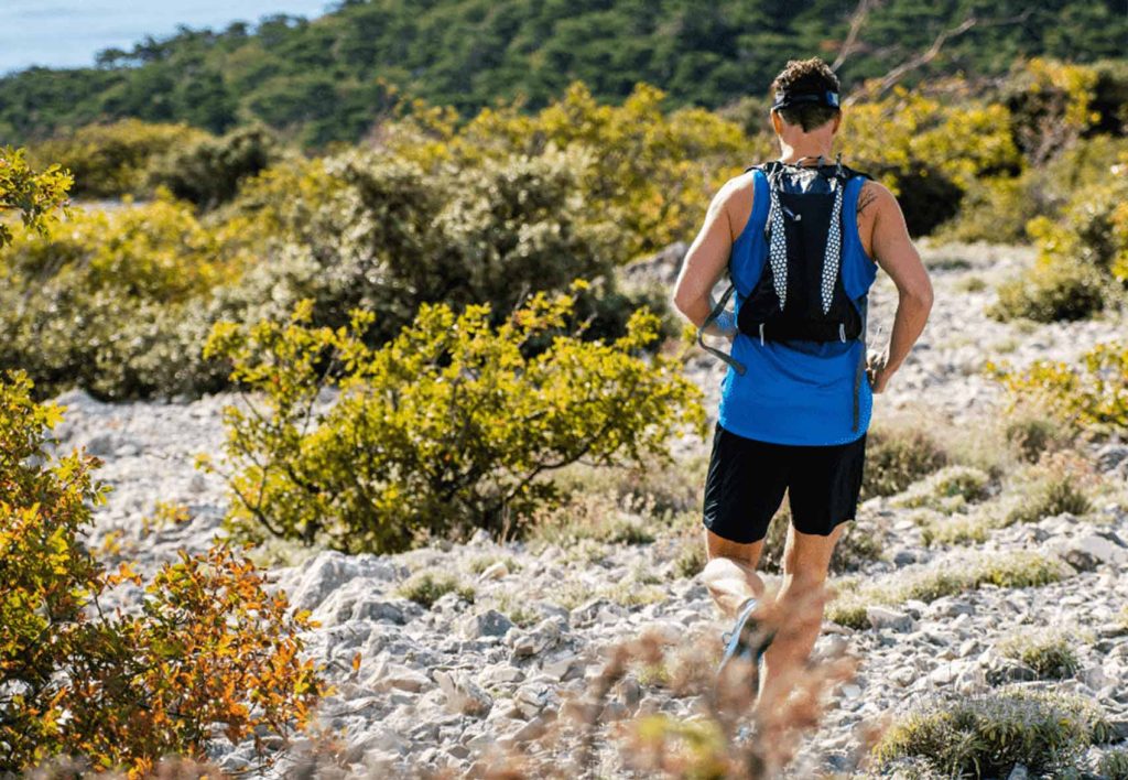 Pessoa usando colete de hidratação em uma corrida de trilha