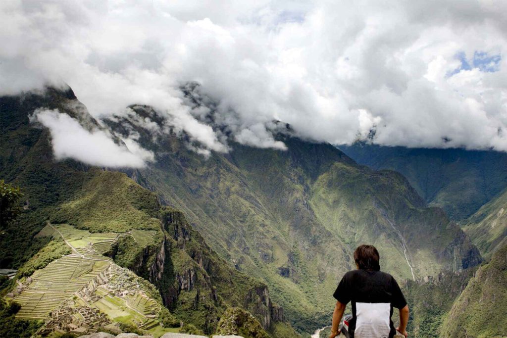 turista respirando fundo enquanto observa a cidadela inca de Machu Picchu