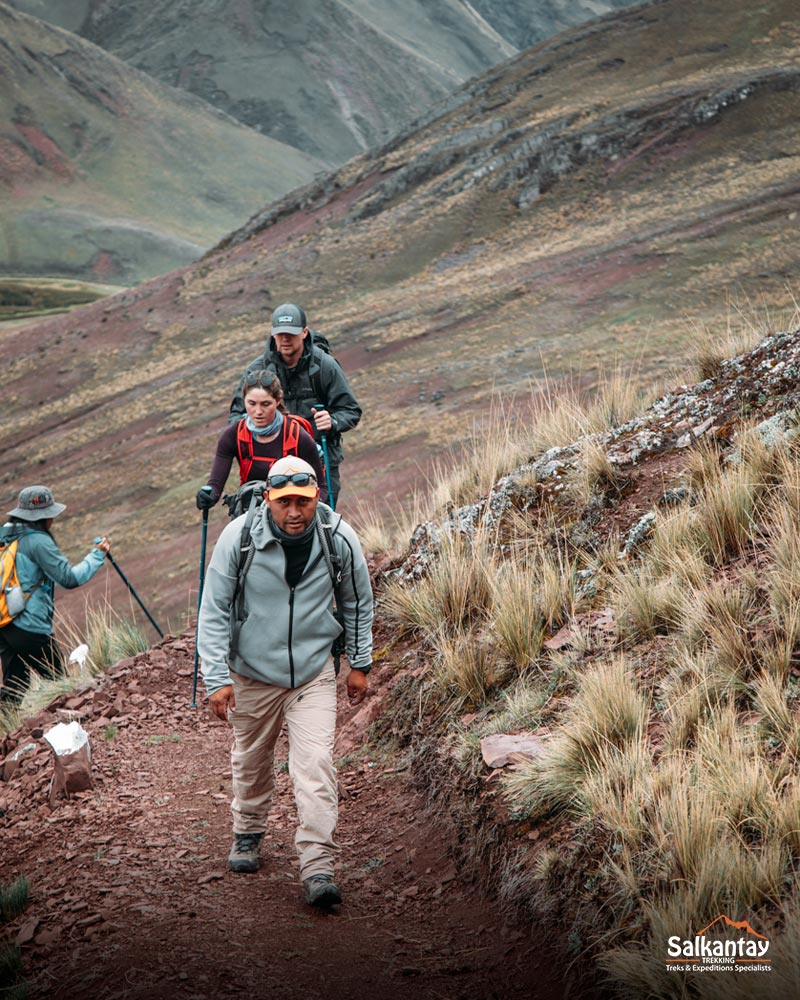 Turistas e seu guia caminhando em direção à colorida montanha Pallay Punchu.