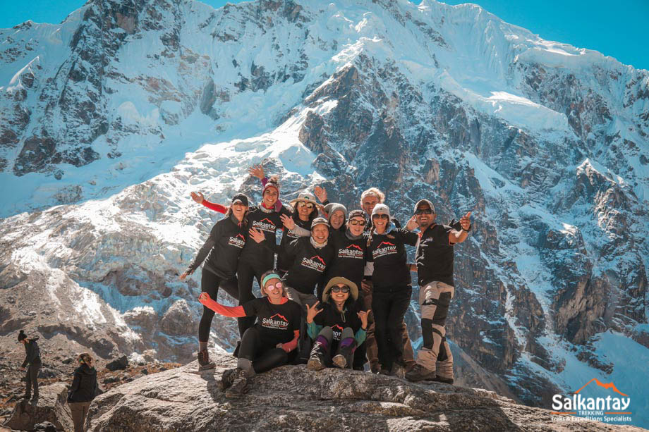 Grupo de turistas em pé sobre uma rocha na passagem de Salkantay