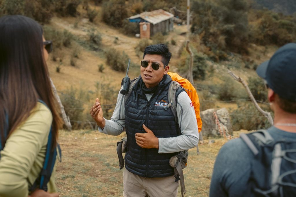 Guia turístico explicando a rota de caminhada da Trilha Salkantay para um grupo de turistas.