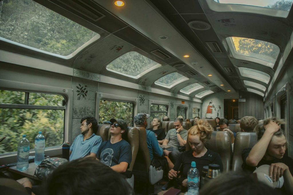 Turistas sentados em um trem para Machu Picchu