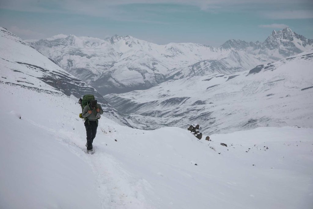 Turista com equipamento de caminhada explorando as montanhas nevadas de Ausangate.