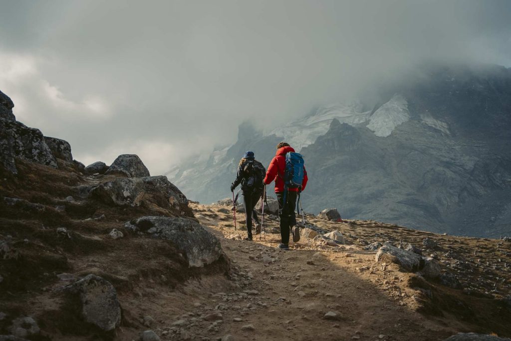 Casal de turistas caminhando pela Passagem de Salkantay com equipamento completo de montanhismo