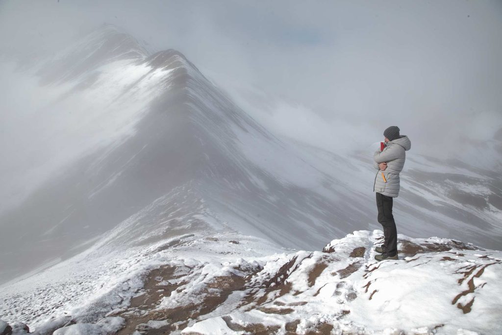 Um turista na Montanha Arco-Íris, em meio ao frio glacial.
