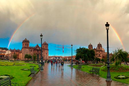 Plaza principal de la ciudad de Cusco con un arco iris en el cielo
