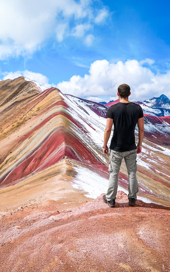 Turista observando a magnífica Montanha Arco-Íris (Vinicunca), famosa por suas sete cores na cordilheira do Cusco, Peru.