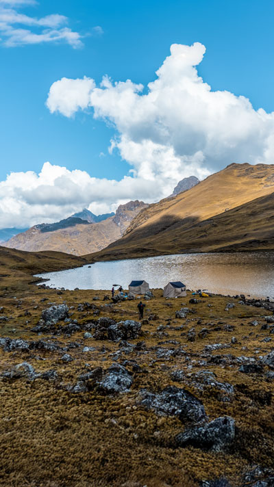 Vista panorâmica de um acampamento ao lado de uma lagoa nos Andes de Lares, no Peru.