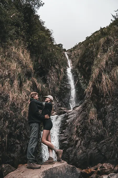 Casal de turistas em uma cachoeira impressionante