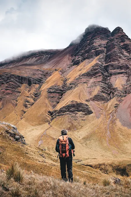 Turista com sua mochila de caminhada na imensidão das montanhas