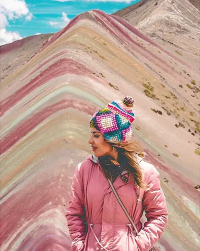 Turista apreciando o vento dos Andes na montanha do arco-íris.